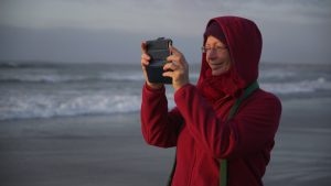 Løvetannmamma - Woman taking a picture of the beach